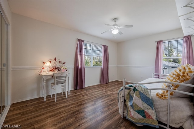 bedroom with dark hardwood / wood-style floors, ceiling fan, and multiple windows