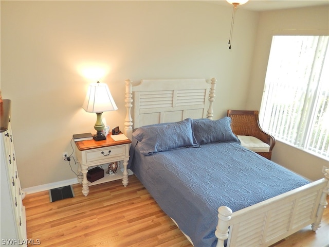 bedroom with light hardwood / wood-style flooring and multiple windows