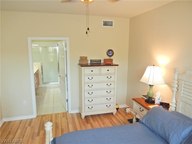 bedroom with ensuite bathroom, light wood-type flooring, and ceiling fan