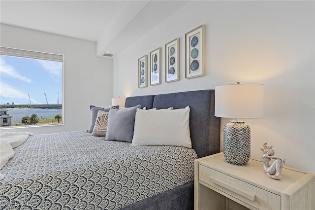 bedroom with carpet and a water view