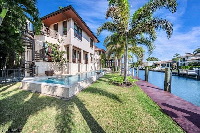 exterior space featuring a lawn, a water view, and a dock