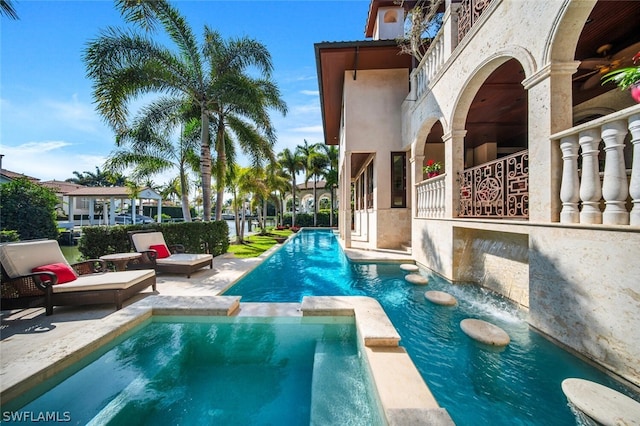 view of swimming pool featuring a patio area and an in ground hot tub