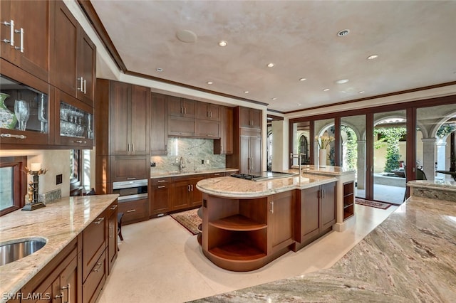 kitchen with light stone countertops, sink, and ornamental molding