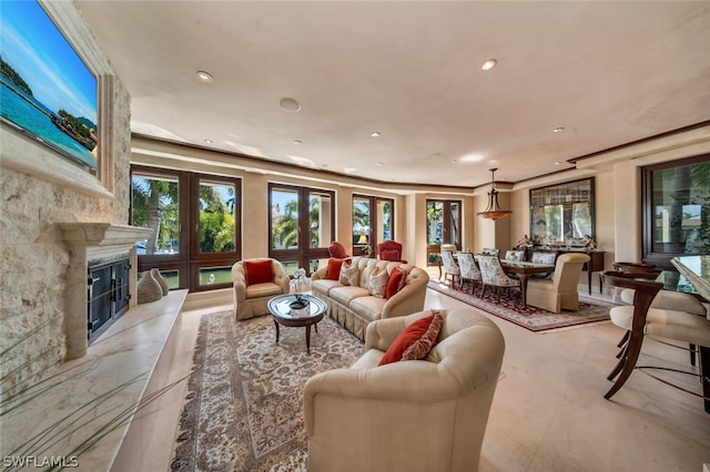 living room with a premium fireplace, crown molding, a healthy amount of sunlight, and french doors