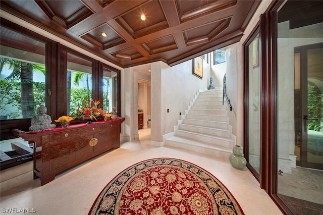 carpeted foyer with beam ceiling, crown molding, and coffered ceiling