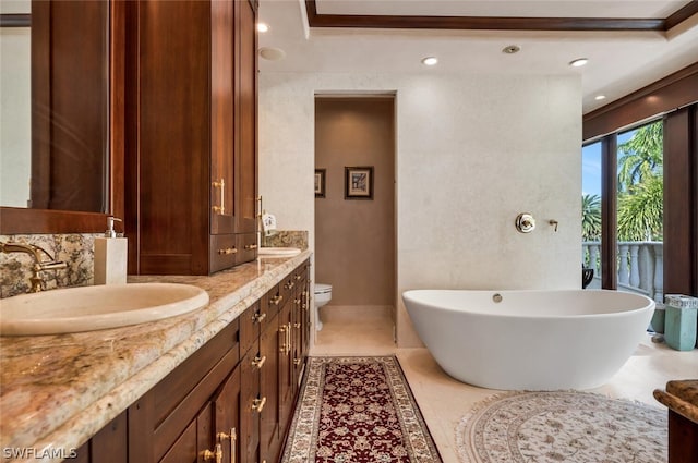 bathroom featuring tile patterned floors, a bathtub, toilet, and vanity