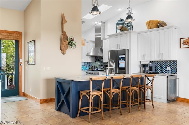 kitchen with a skylight, decorative light fixtures, high vaulted ceiling, stainless steel fridge with ice dispenser, and white cabinetry