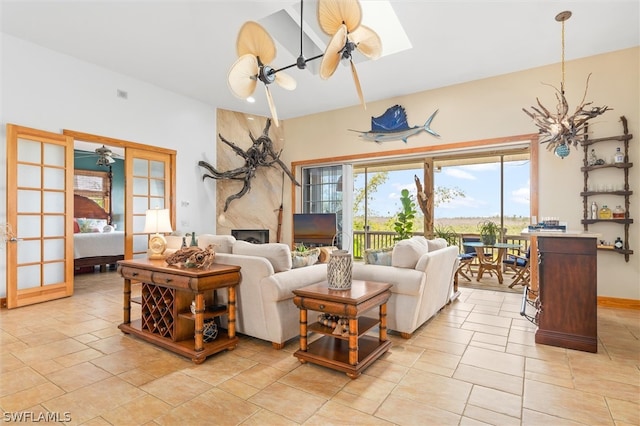 tiled living room featuring a skylight, ceiling fan, and a premium fireplace