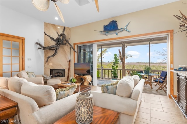 tiled living room featuring ceiling fan and a premium fireplace