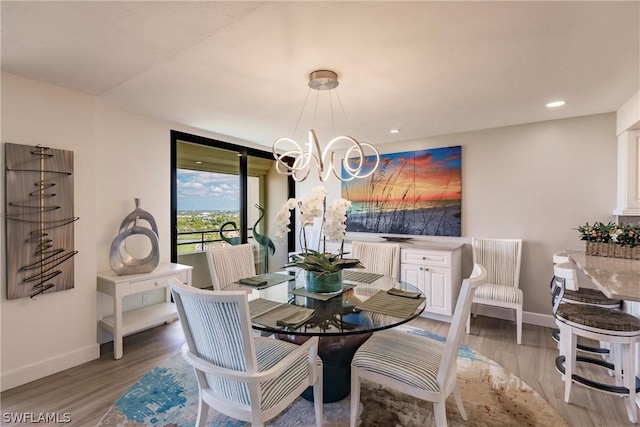 dining area featuring light hardwood / wood-style floors and a notable chandelier