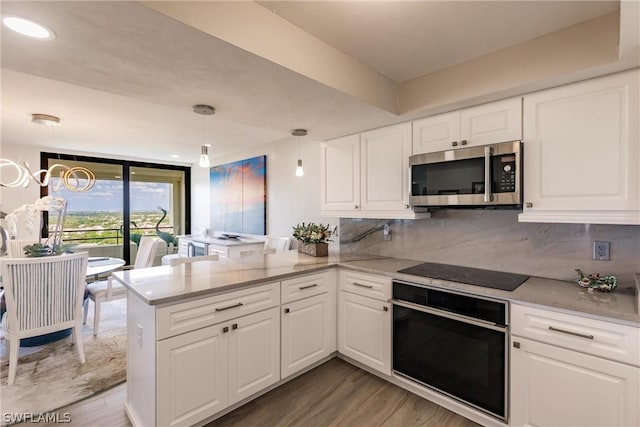 kitchen featuring kitchen peninsula, white cabinets, and black appliances