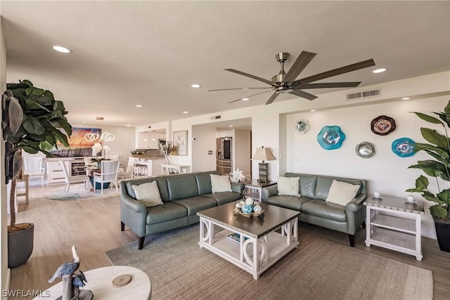 living room featuring ceiling fan and light hardwood / wood-style flooring