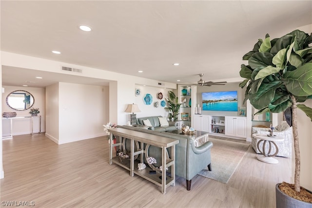 living room with ceiling fan and light hardwood / wood-style flooring