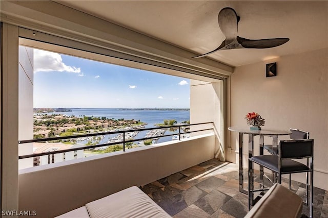 balcony with a water view and ceiling fan