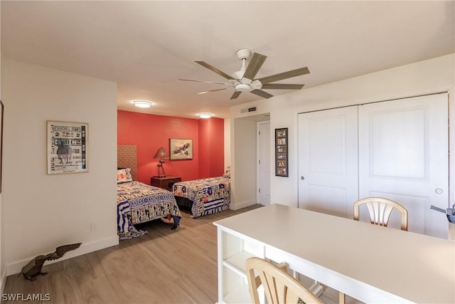 bedroom with a closet, light hardwood / wood-style flooring, and ceiling fan