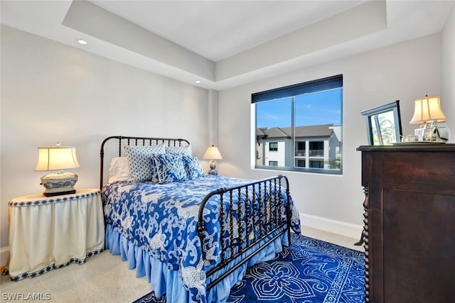 bedroom with a raised ceiling and carpet