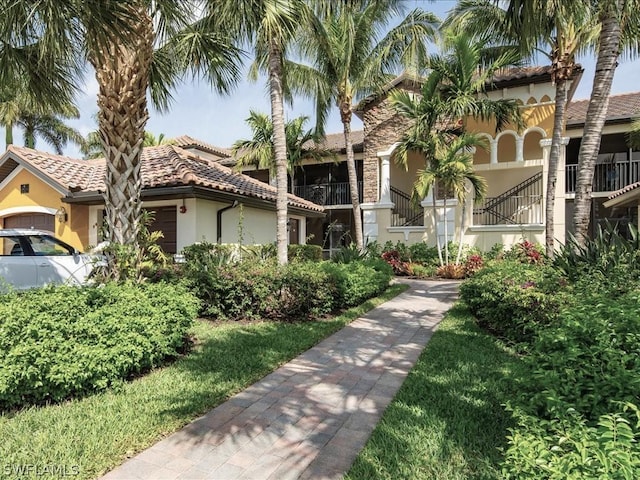 exterior space featuring stucco siding, a tile roof, and a garage