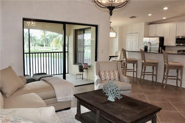 living area with dark tile patterned floors, recessed lighting, visible vents, and ornamental molding