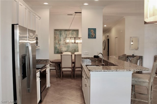 kitchen with a breakfast bar, a peninsula, stainless steel appliances, white cabinetry, and crown molding