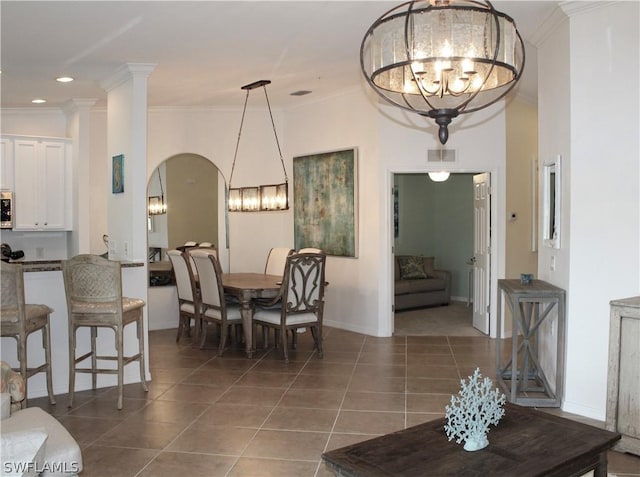 dining room with visible vents, crown molding, arched walkways, tile patterned floors, and a notable chandelier