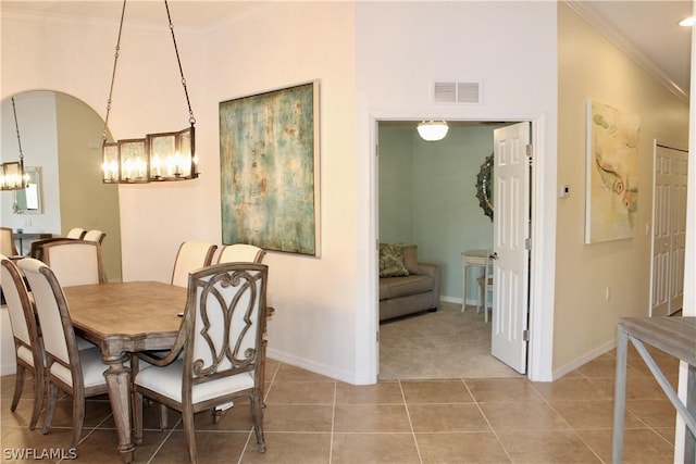 dining area with an inviting chandelier, crown molding, light tile patterned floors, and visible vents