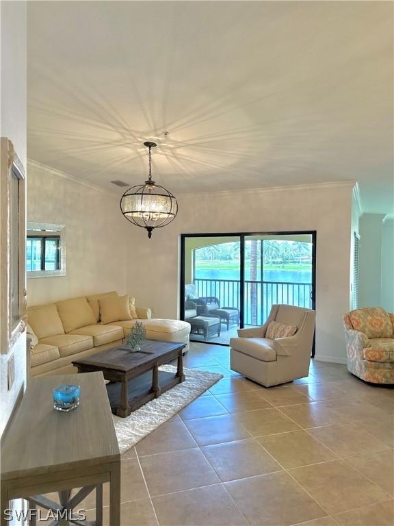 living room featuring crown molding, light tile patterned floors, and a chandelier