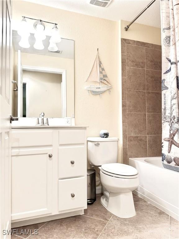 bathroom with vanity, visible vents, tile patterned floors, toilet, and shower / tub combo with curtain