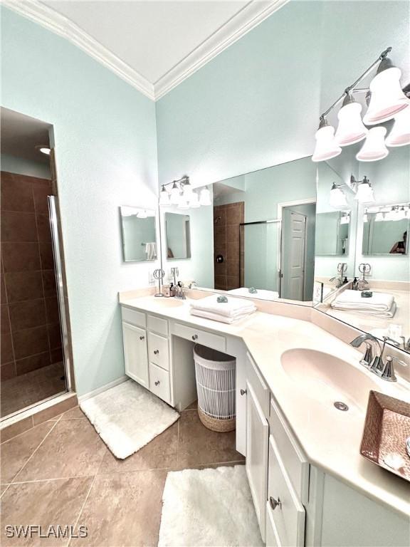 full bath with double vanity, a sink, a shower stall, crown molding, and tile patterned floors