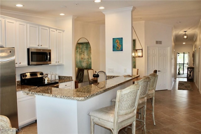 9509 Avellino Way Unit 1823, Naples, FL 34113 - kitchen with appliances with stainless steel finishes, dark stone countertops, white cabinetry, crown molding, and dark tile patterned floors