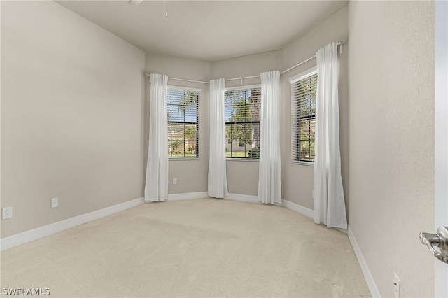 carpeted spare room with ceiling fan