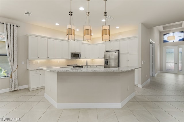 kitchen featuring white cabinets, an island with sink, french doors, and stainless steel appliances