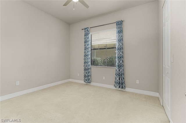 unfurnished room with light colored carpet and ceiling fan