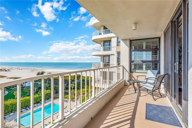 balcony featuring a beach view and a water view