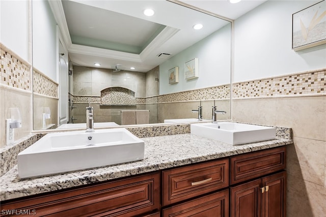 bathroom with vanity, tasteful backsplash, a tray ceiling, and tile walls