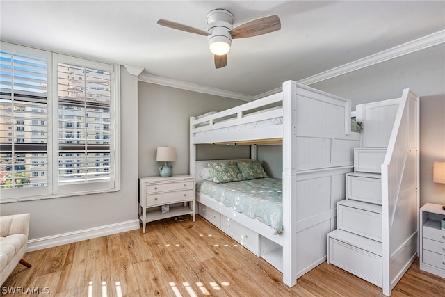 unfurnished bedroom featuring ceiling fan, crown molding, and light hardwood / wood-style flooring