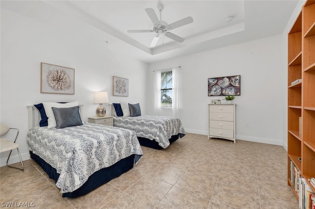 bedroom with ceiling fan and a raised ceiling