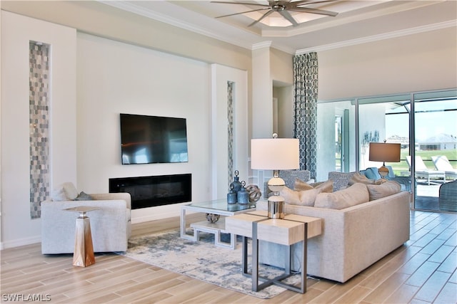 living room with ornamental molding, ceiling fan, and light hardwood / wood-style flooring