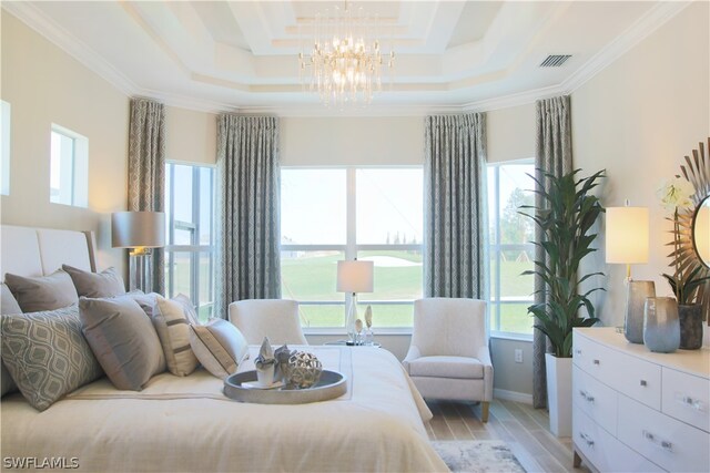 bedroom with a chandelier, multiple windows, and a tray ceiling