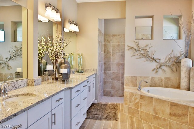 bathroom featuring vanity and tiled tub