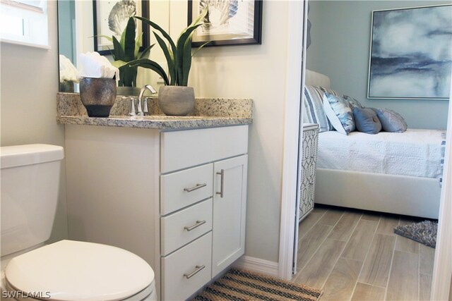 bathroom featuring hardwood / wood-style flooring, toilet, and vanity