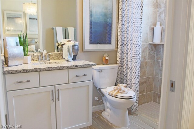 bathroom featuring walk in shower, toilet, and vanity with extensive cabinet space