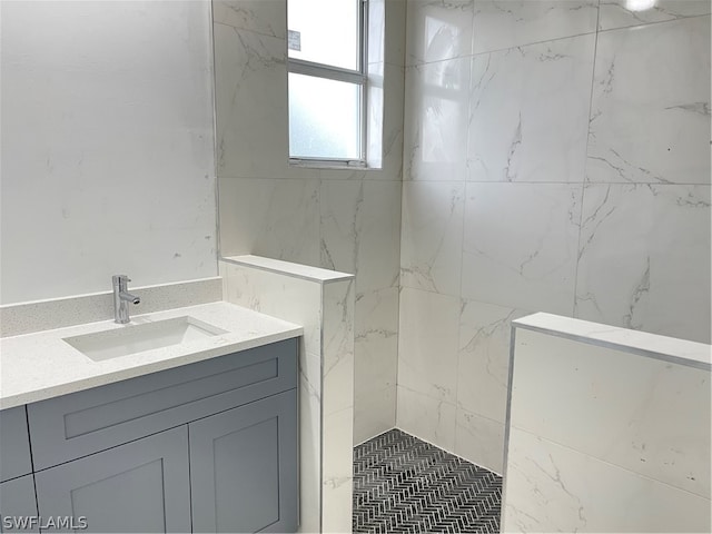 bathroom featuring tiled shower and vanity