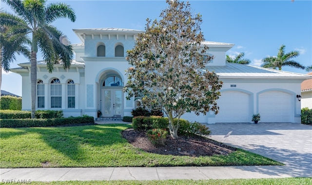 view of front of house featuring french doors, a front yard, and a garage