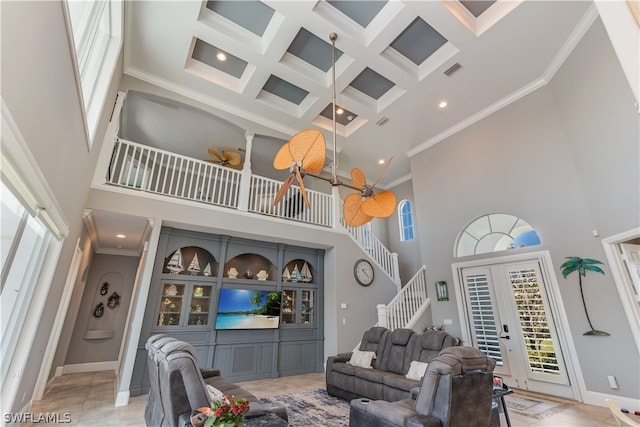 tiled living room featuring crown molding, coffered ceiling, and a high ceiling