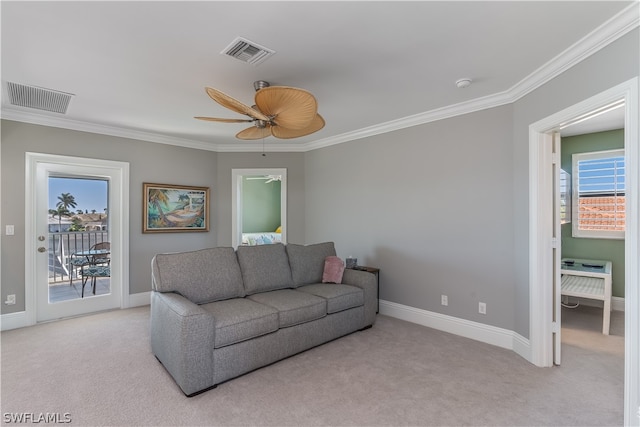 carpeted living room with plenty of natural light, ornamental molding, and ceiling fan