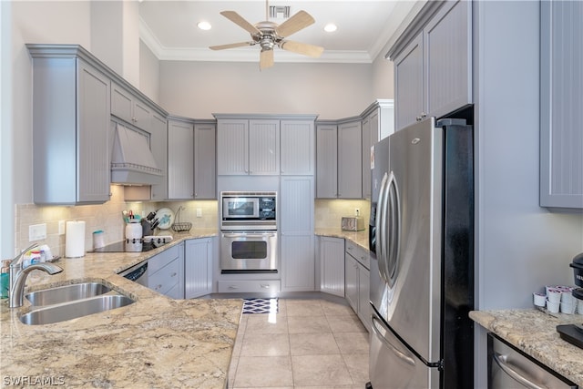 kitchen featuring ceiling fan, sink, custom range hood, stainless steel appliances, and light stone countertops