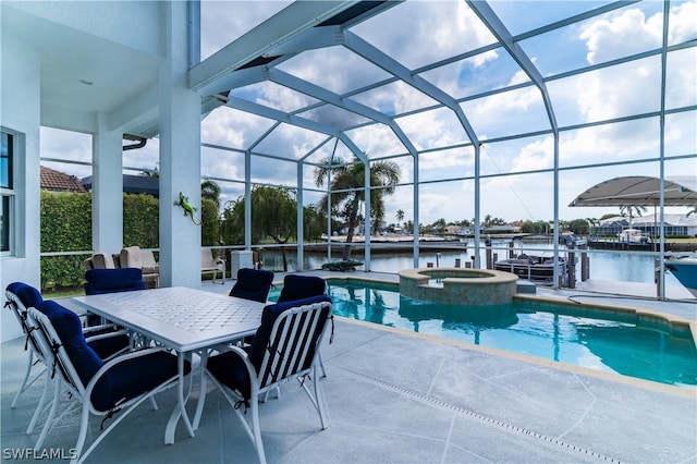 view of pool with an in ground hot tub, a water view, glass enclosure, and a patio area