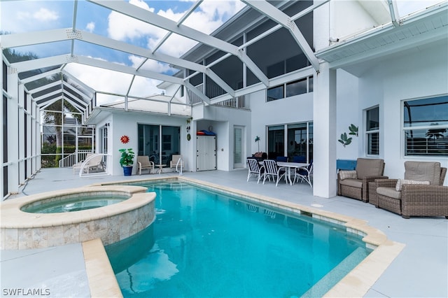 view of pool with a patio, an in ground hot tub, and glass enclosure