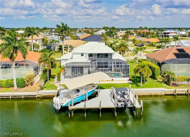 dock area with a lawn, glass enclosure, and a water view