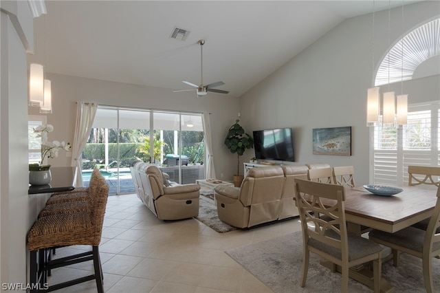 dining room with light tile patterned flooring, high vaulted ceiling, ceiling fan, and plenty of natural light